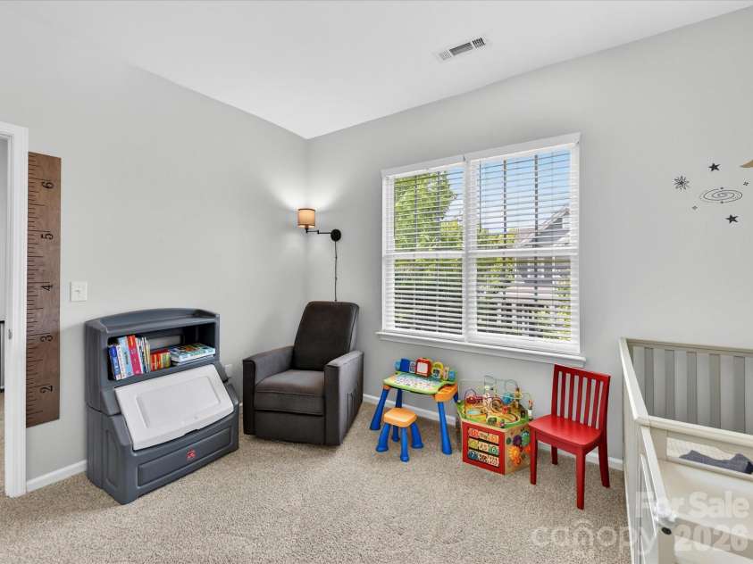 15224 Waterfront Drive, Huntersville, NC 28078.  MLS# CAR4374936, YatesRealty ID 24231. Bright and spacious secondary bedroom featuring plush carpeting, large windows for natural light, and flexible space perfect for a nursery, guest room, or home office.