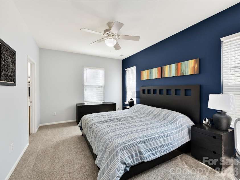 15224 Waterfront Drive, Huntersville, NC 28078.  MLS# CAR4374936, YatesRealty ID 24231. Spacious primary suite featuring vaulted ceilings, abundant natural light, plush carpeting, and a stylish accent wall creating a relaxing retreat.