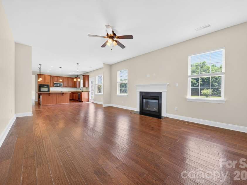 1008 Spring Rose Lane, Matthews, NC 28104.  MLS# CAR4382906, YatesRealty ID 24258. Expansive main living area featuring gas fireplace, backyard views, and open design connecting seamlessly to the kitchen and adjoining living spaces.