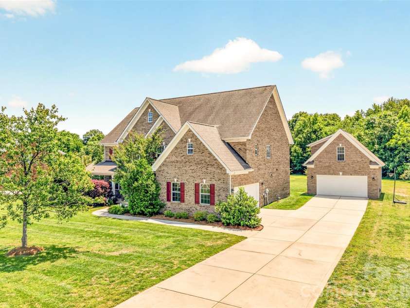 1008 Spring Rose Lane, Matthews, NC 28104.  MLS# CAR4382906, YatesRealty ID 24258. Full brick 5 bedroom, 4 full bath residence featuring a detached 2 car garage and finished flex space above with an additional full bathroom, offering versatility for a variety of lifestyle needs.