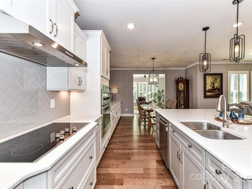 5129 Devonshire Road, Denver, NC 28037.  MLS# CAR4275511, YatesRealty ID 24318. Extremely Upgraded Kitchen offers quartz counters, island with seating/storage, stainless steel appliances, tile back splash, hood system, plenty of cabinetry for storage, custom lighting, walk in pantry with wood shelvi