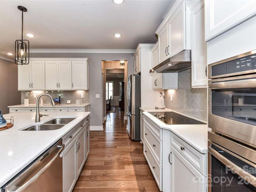 5129 Devonshire Road, Denver, NC 28037.  MLS# CAR4275511, YatesRealty ID 24318. Extremely Upgraded Kitchen offers quartz counters, island with seating/storage, stainless steel appliances, tile back splash, hood system, plenty of cabinetry for storage, custom lighting, walk in pantry with wood shelvi