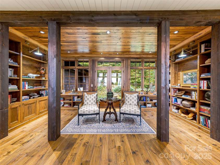 616 Old Growth Forest Road, Burnsville, NC 28714.  MLS# CAR4076276, YatesRealty ID 2437. Speaking of warmth, enjoy the cozy comfort of this dedicated library! Should you elect to exit through those glass French doors...