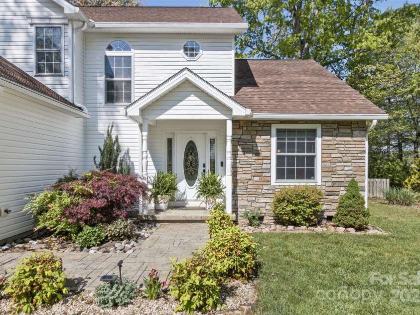 301 Theron Court, Candler, NC 28715.  MLS# CAR4250972, YatesRealty ID 24385. Beautiful gardens  line the stone walkway
