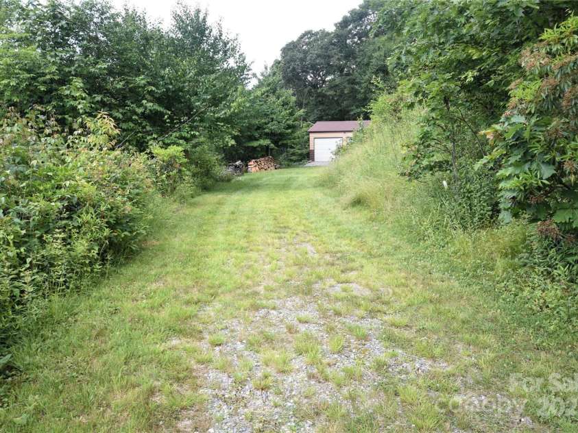 211 Sky Drive, Maggie Valley, NC 28751.  MLS# CAR4276346, YatesRealty ID 24456. Side trail below the cabin to the garage/workshop