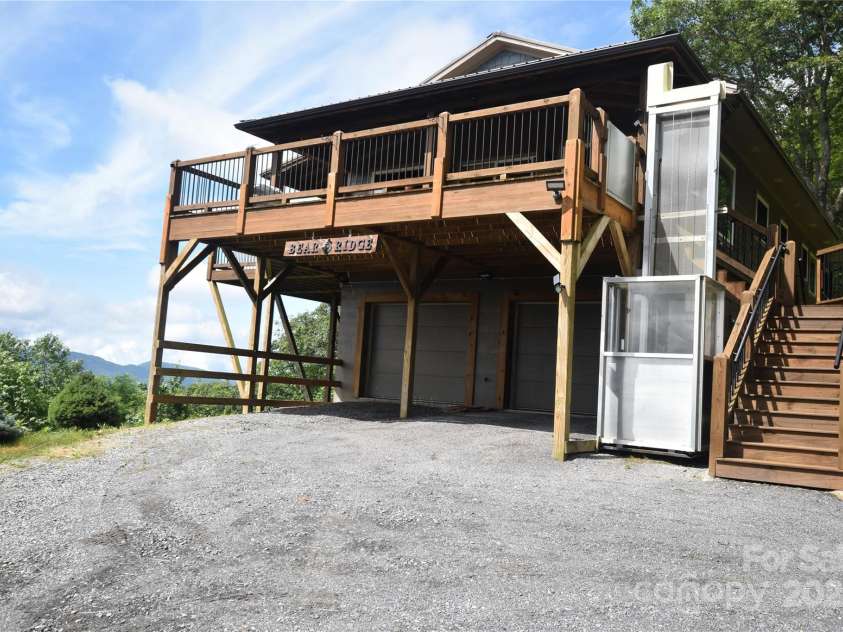 211 Sky Drive, Maggie Valley, NC 28751.  MLS# CAR4276346, YatesRealty ID 24456. There is an aluminum framed outdoor elevator next to the stairs