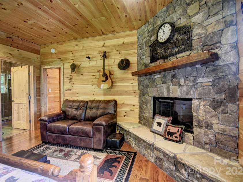 211 Sky Drive, Maggie Valley, NC 28751.  MLS# CAR4276346, YatesRealty ID 24456. Wood-Burning Fireplace and sitting area in the primary bedroom
