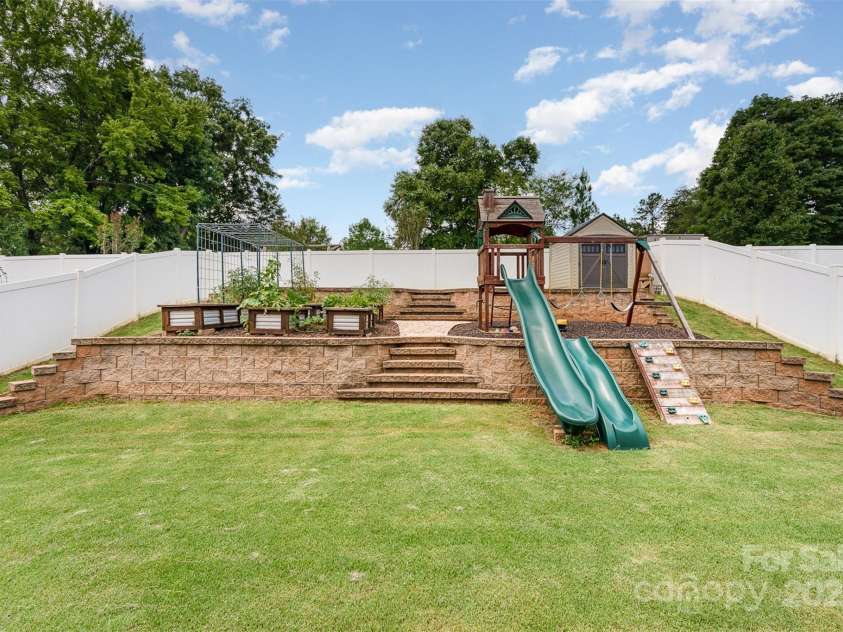 133 Glade Valley Avenue, Mooresville, NC 28117.  MLS# CAR4275294, YatesRealty ID 24460. Tiered backyard garden and play area