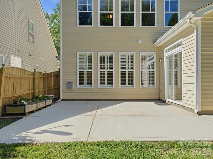 10094 Paisley Drive, Charlotte, NC 28269.  MLS# CAR4382557, YatesRealty ID 24509. Rear elevation showcases abundant natural light through oversized windows and direct patio access from the sunroom.