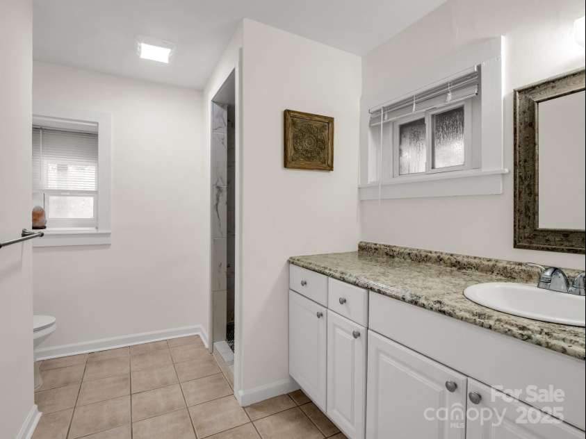 1463 Carolina Drive, Tryon, NC 28782.  MLS# CAR4275838, YatesRealty ID 24578. Full bathroom in the basement with a tile shower