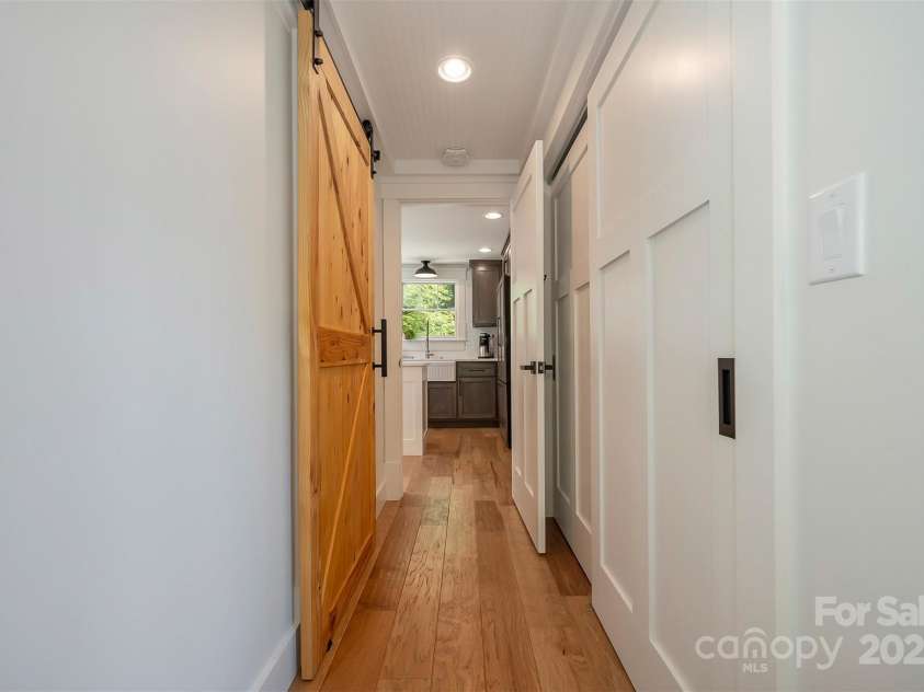 54 Holland Drive, Columbus, NC 28722.  MLS# CAR4309470, YatesRealty ID 2459. Hall of primary bedroom with closet and entry to main level bath