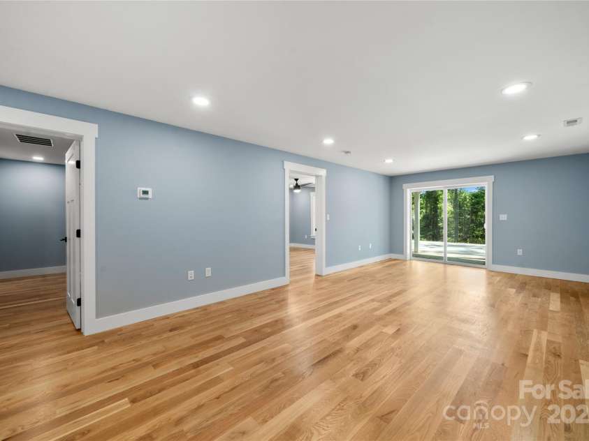 68 Bamboo Trail, Candler, NC 28715.  MLS# CAR4257307, YatesRealty ID 24635. Lower level living area with bedroom door to left of sliding door and zero entry access from second driveway
