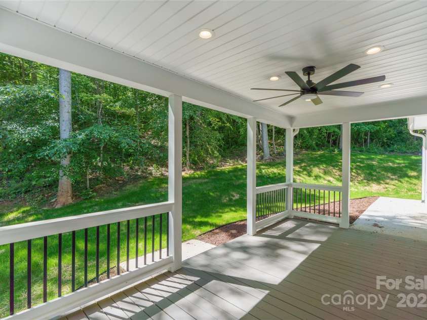 68 Bamboo Trail, Candler, NC 28715.  MLS# CAR4257307, YatesRealty ID 24635. Rear covered porch with lighted path leading to exterior garage door