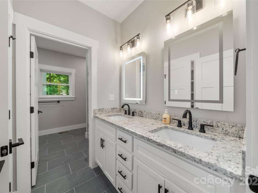 68 Bamboo Trail, Candler, NC 28715.  MLS# CAR4257307, YatesRealty ID 24635. Spacious dual vanities in the ensuite primary bath