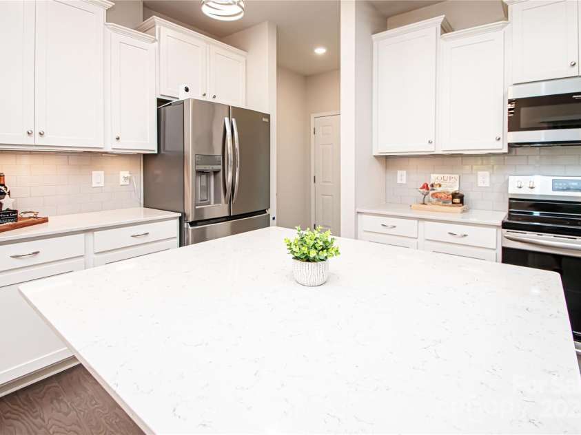 17718 Terryglass Lane, Charlotte, NC 28278.  MLS# CAR4274833, YatesRealty ID 24679. Beautiful kitchen with white cabinets, quarts countert tops, stainless steel appliances, tile back splash and kitchen island.