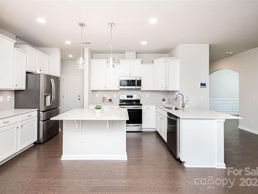 17718 Terryglass Lane, Charlotte, NC 28278.  MLS# CAR4274833, YatesRealty ID 24679. Beautiful kitchen with white cabinets, quarts countert tops, stainless steel appliances, tile back splash and kitchen island.