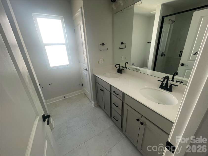 4049 Grommet Court, Matthews, NC 28105.  MLS# CAR4325054, YatesRealty ID 24731. Dual sinks and drawer bank with walk in shower, linen closet in Primary Bath