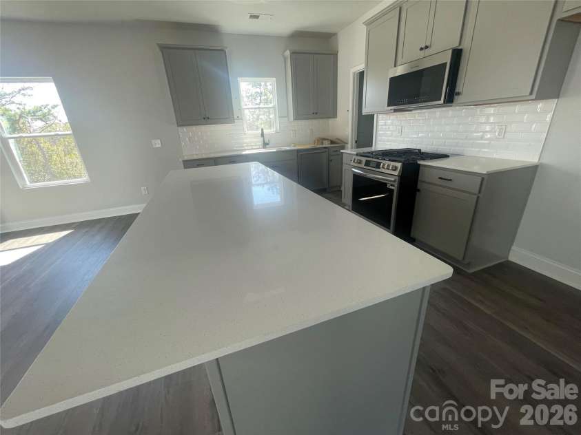 4049 Grommet Court, Matthews, NC 28105.  MLS# CAR4325054, YatesRealty ID 24731. Quartz countertops in kitchen, subway tile backsplash, large  stainless steel sink, gas stove top and the microwave can even be used as an Air Fryer 