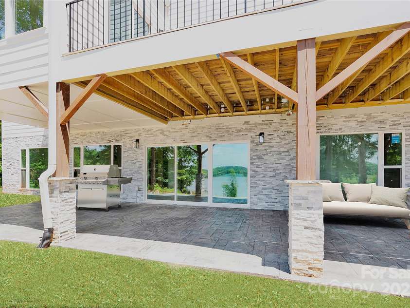 124 Clipper Lane, Mooresville, NC 28117.  MLS# CAR4253640, YatesRealty ID 24732. Virtually staged lake front covered patio is ready for your outdoor kitchen