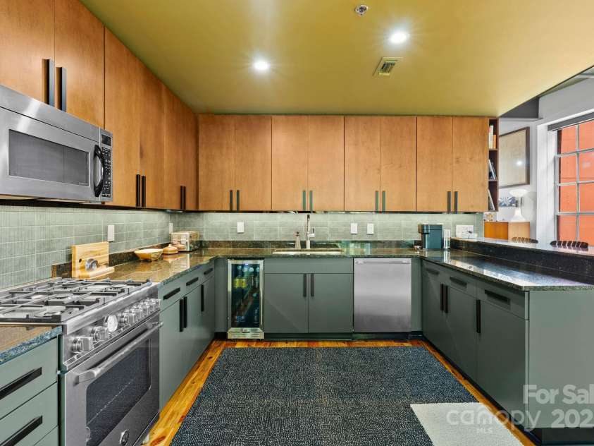 100 Coxe Avenue, Asheville, NC 28801.  MLS# CAR4271737, YatesRealty ID 24809. Kitchen area from living room