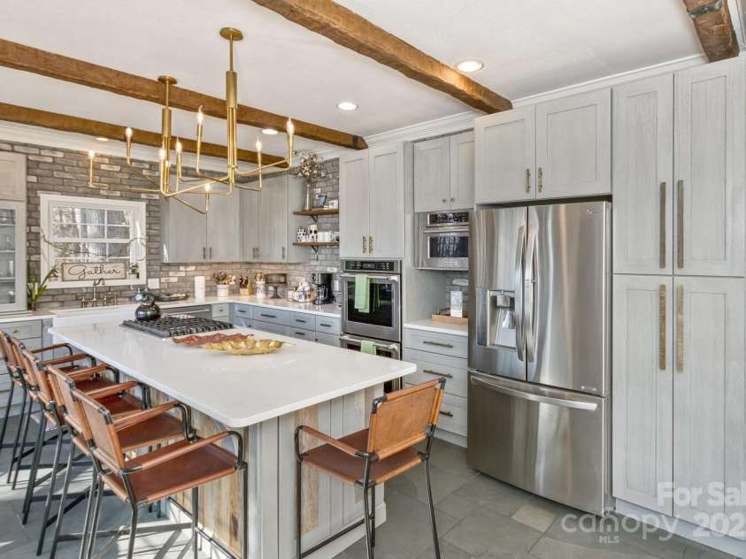 909 Town Mountain Road, Asheville, NC 28804.  MLS# CAR4233490, YatesRealty ID 2483. The large, sleek kitchen is a cook's delight and features a generous island that is another ideal gathering place.