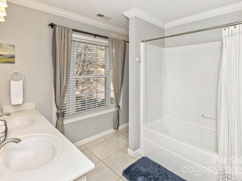 909 Town Mountain Road, Asheville, NC 28804.  MLS# CAR4233490, YatesRealty ID 2483. The upstairs guest bathroom has a double vanity and shower tub.