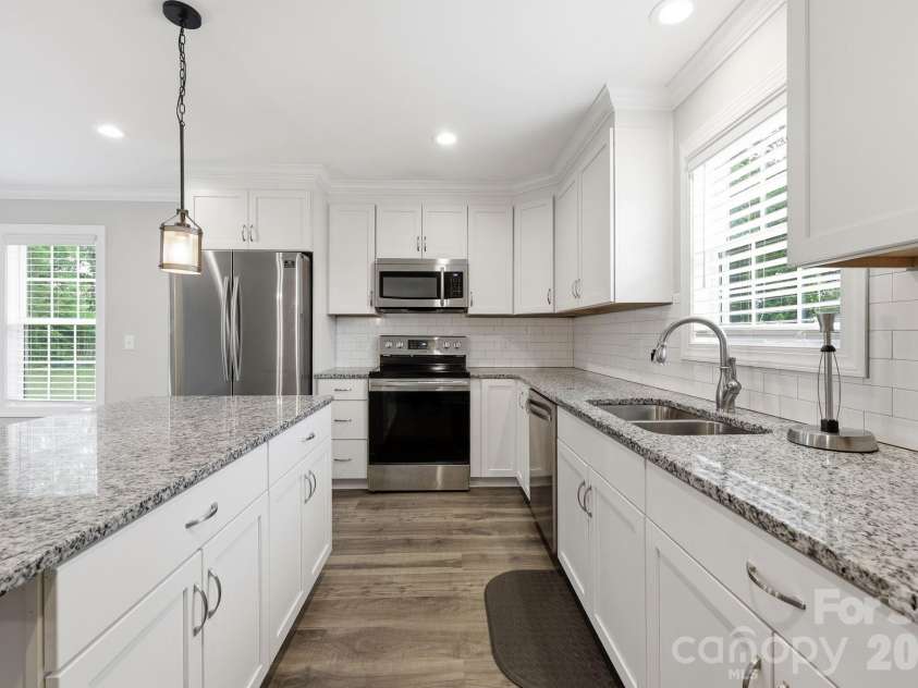 2601 Penninger Road, Concord, NC 28025.  MLS# CAR4381603, YatesRealty ID 24870. White cabinets, granite countertops and tile the backsplash make the kitchen shine!