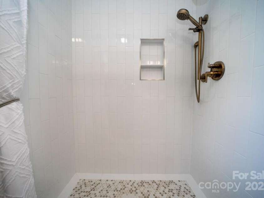 216 Tinequa Drive, Brevard, NC 28712.  MLS# CAR4275576, YatesRealty ID 24874. Custom-tiled walk in shower with grab bar