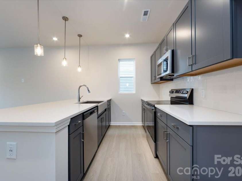 6017 Longar Lane, Charlotte, NC 28269.  MLS# CAR4356792, YatesRealty ID 24944. Chef-inspired kitchen with rich grey cabinets