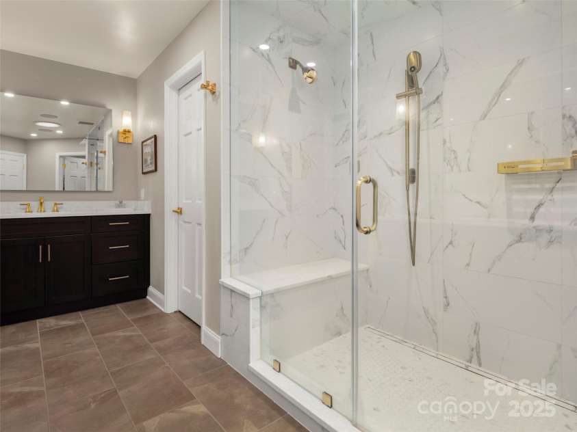 3301 Timber Trail, Asheville, NC 28804.  MLS# CAR4270898, YatesRealty ID 25068. Large modern walk-in shower in the primary en-suite bathroom.