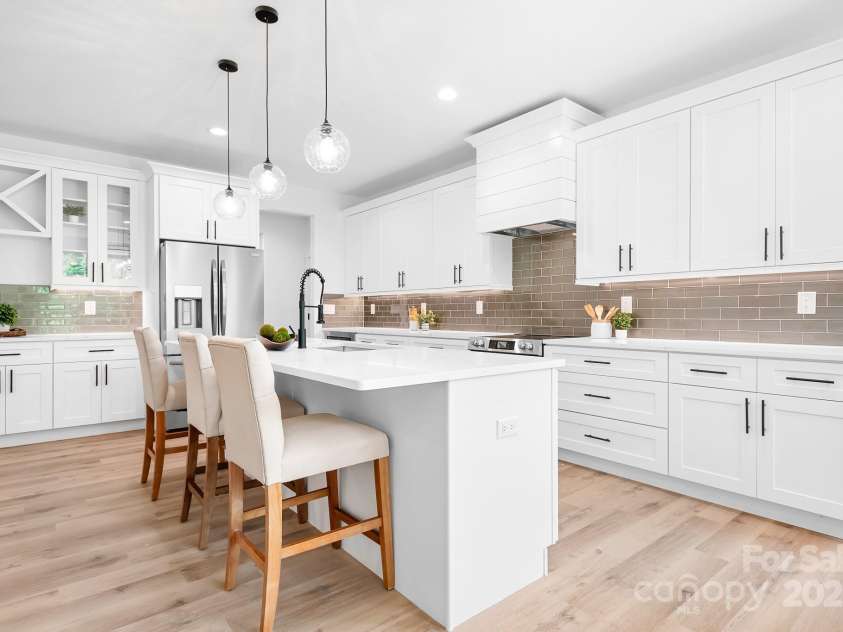 104 Arbor Drive, Waxhaw, NC 28173.  MLS# CAR4258251, YatesRealty ID 25109. Statement lighting, clean cabinetry, and that glossy subway tile—this kitchen nails the modern farmhouse look with a designer twist.