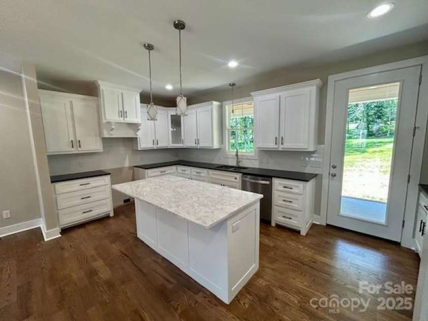 141 Maplewood Court, Hudson, NC 28638.  MLS# CAR4279245, YatesRealty ID 25127. Kitchen area with bar.  Double oven electric range to be installed soon. All cabinets are custom built.  Solid surface counter tops with subway tile backsplash. Door to the outside goes to back porch.