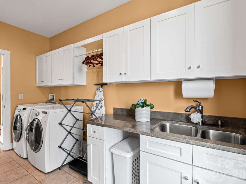 404 Amanda Drive, Mars Hill, NC 28754.  MLS# CAR4374158, YatesRealty ID 25181. :aundry Room off the kitchen with plenty of shelves on the opposite wall.