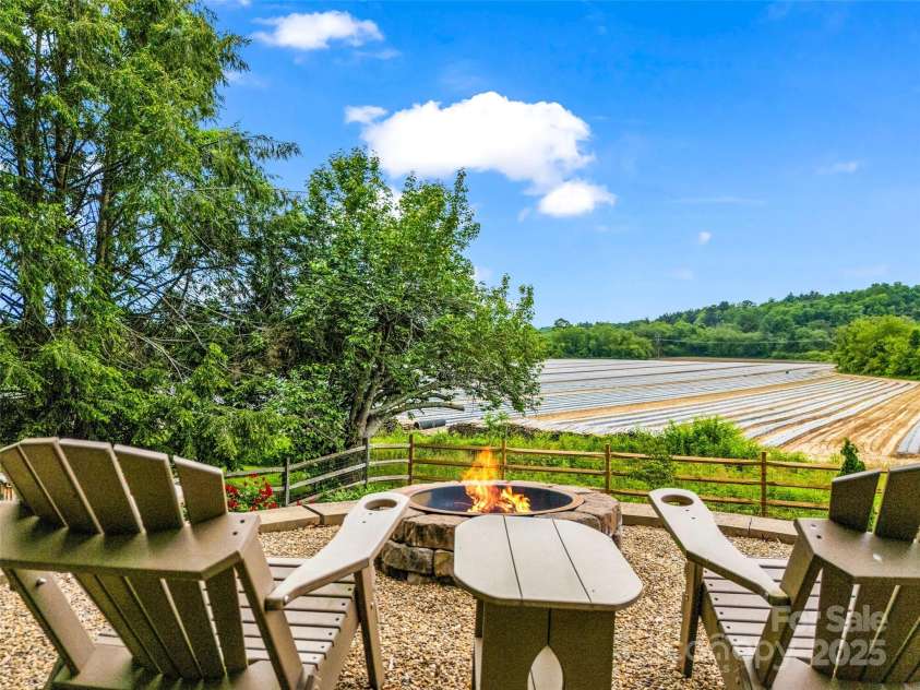 11 Bannerwood Drive, Horse Shoe, NC 28742.  MLS# CAR4257161, YatesRealty ID 25194. Fire pit with mountain views and vegetable farm