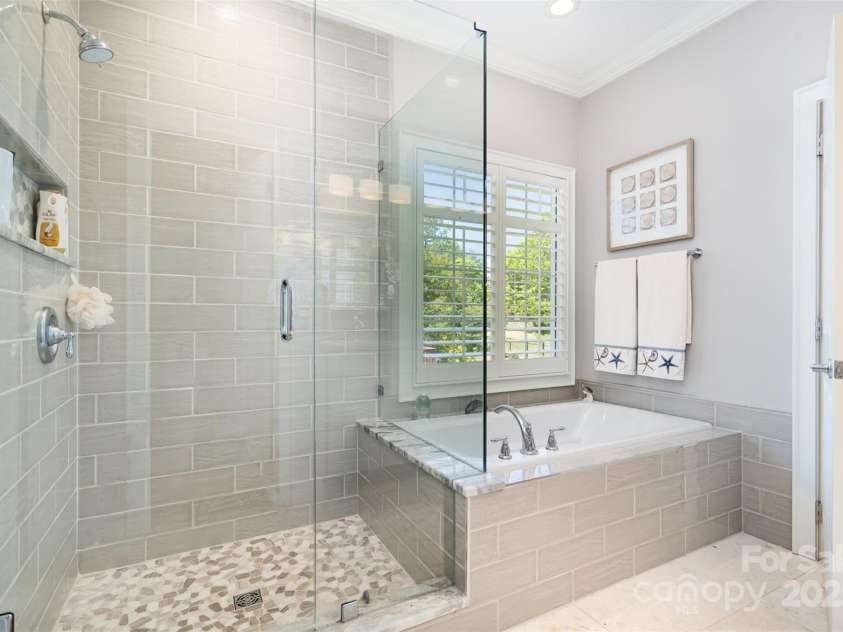 3813 Beauvista Drive, Charlotte, NC 28269.  MLS# CAR4275235, YatesRealty ID 25268. River rock bottom step in shower with frameless glass doors, and look at that spacious soaking tub!