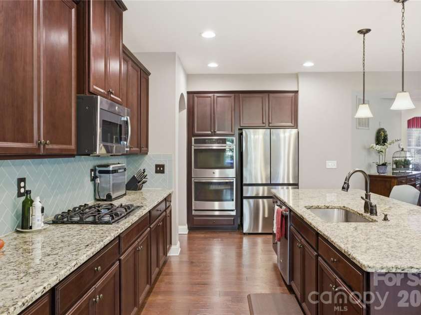8306 Early Bird Way, Mint Hill, NC 28227.  MLS# CAR4375925, YatesRealty ID 25288. Beautifully appointed kitchen featuring rich cabinetry, granite countertops, stainless steel appliances and a spacious center island with sink and bar seating. Complete with a built-in double oven and designed for both