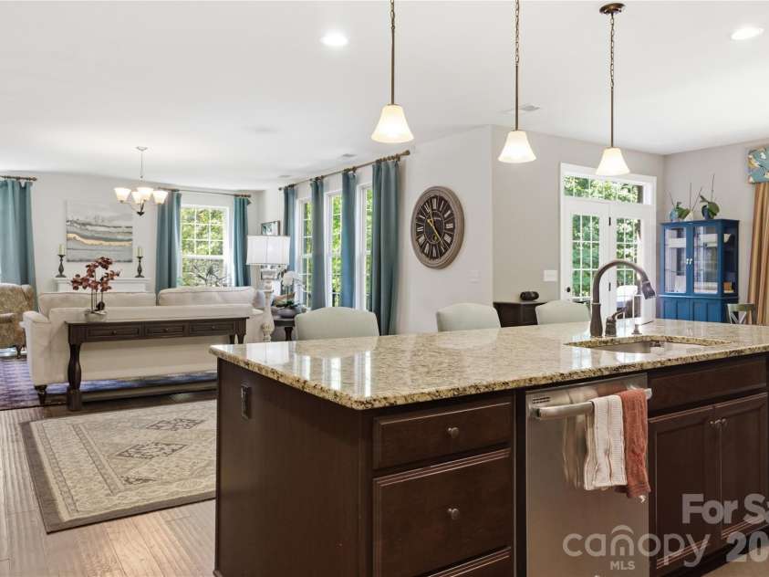 8306 Early Bird Way, Mint Hill, NC 28227.  MLS# CAR4375925, YatesRealty ID 25288. Expansive open-concept living area anchored by a stunning oversized kitchen island with beautiful granite countertops, ample seating, and filled with natural light. The seamless connection between the kitchen, dining, 