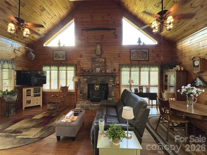 361 Black Camp Gap Road, Maggie Valley, NC 28751.  MLS# CAR4383045, YatesRealty ID 25299. LIving area with a wood stove inserted in the fire place. Dining area.