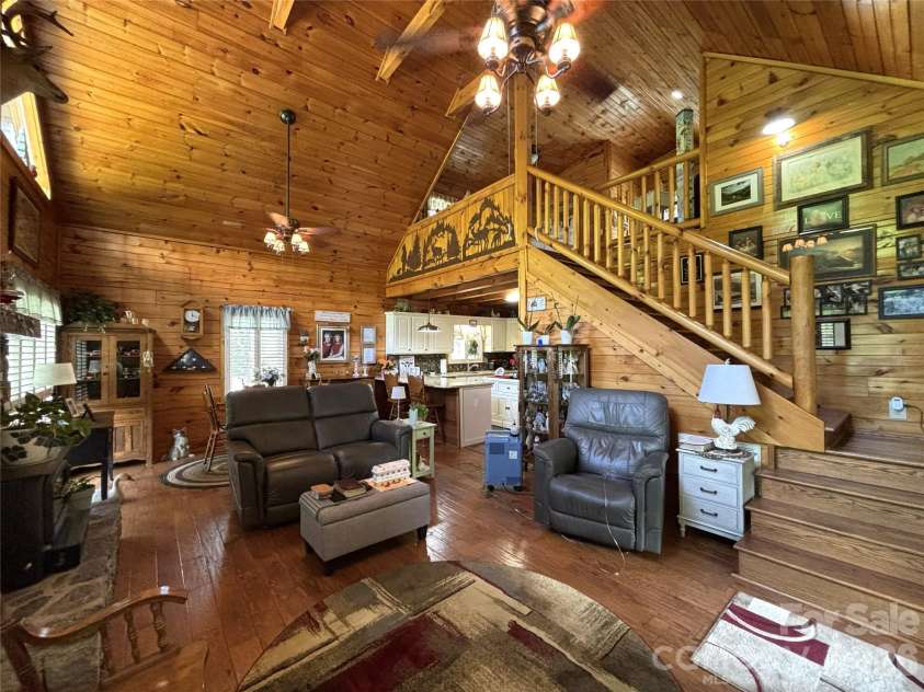 361 Black Camp Gap Road, Maggie Valley, NC 28751.  MLS# CAR4383045, YatesRealty ID 25299. View of the living room, from where the access to the upper level is visible.