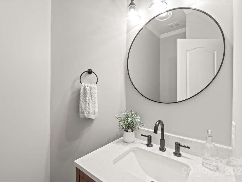 6320 Tilley Way, Matthews, NC 28105.  MLS# CAR4274022, YatesRealty ID 25314. Elevate guest comfort with a powder room that showcases a custom vanity paired with sleek quartz countertops.
