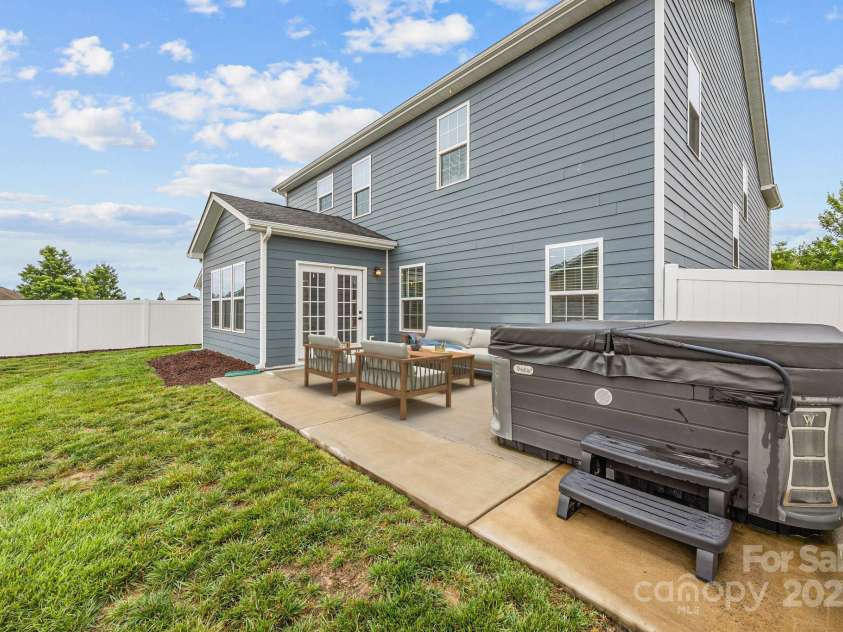 12710 ES Draper Drive, Huntersville, NC 28078.  MLS# CAR4245937, YatesRealty ID 25327. Virtual staging of the back patio with outdoor seating and the hot tub conveys!