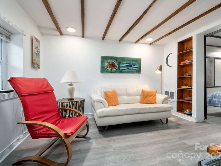 5 Arbutus Road, Asheville, NC 28805.  MLS# CAR4270691, YatesRealty ID 25344. Lower Unit Living Room with Built-In Display Shelving