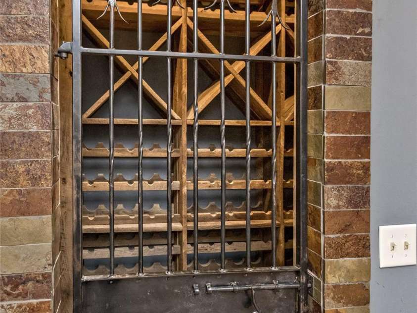 33 Stone House Road, Arden, NC 28704.  MLS# CAR4261250, YatesRealty ID 25362. Custom wine cave with wrought iron door