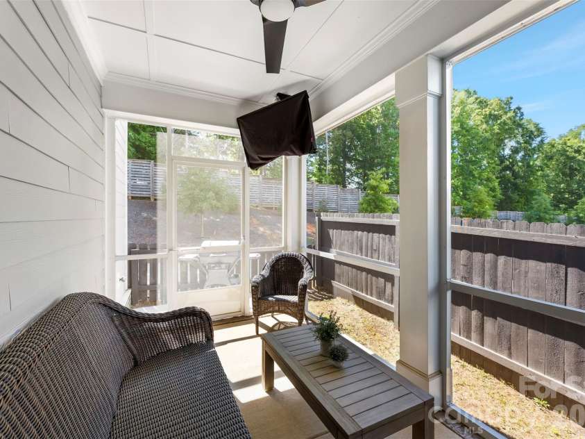 10141 Rainier Trail Drive, Huntersville, NC 28078.  MLS# CAR4375749, YatesRealty ID 25370. Private screened porch featuring an upgraded ceiling fan, offering a tranquil escape and enhanced privacy due to its location backing onto mature trees, perfect for relaxing and enjoying the summer evenings.