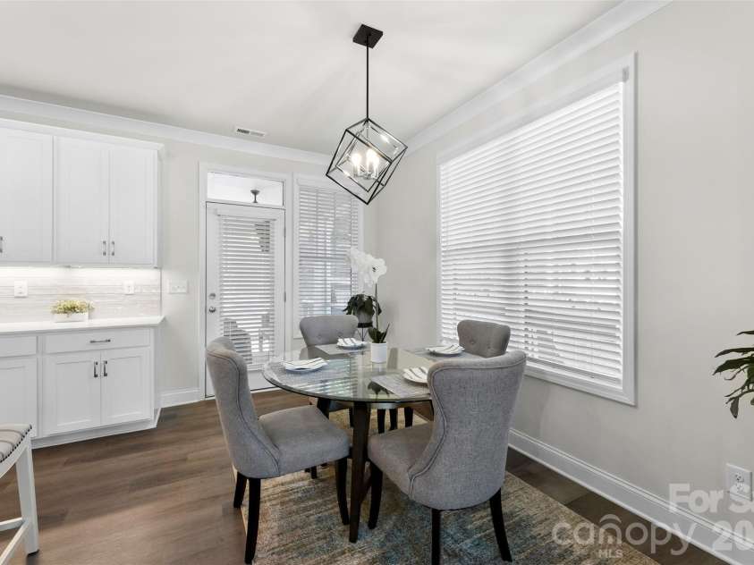 10141 Rainier Trail Drive, Huntersville, NC 28078.  MLS# CAR4375749, YatesRealty ID 25370. The spacious dining area features abundant natural light, enhanced by upgraded lighting fixtures, and seamlessly connects to the inviting screened porch, creating a bright and comfortable space for meals and g