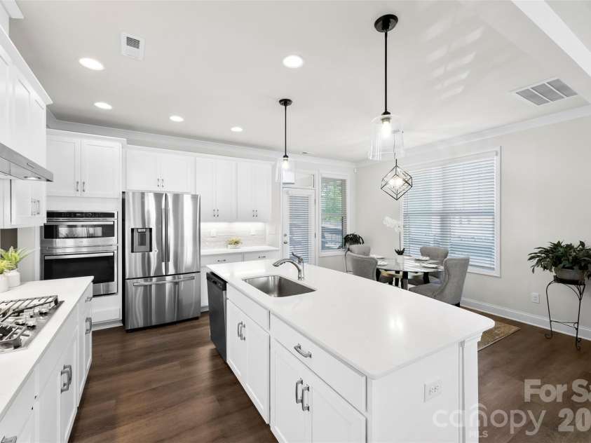 10141 Rainier Trail Drive, Huntersville, NC 28078.  MLS# CAR4375749, YatesRealty ID 25370. This inviting kitchen is designed for both functionality and elegance. Prepare to be impressed by the expansive island, complete with a charming farmhouse sink, making it the ideal centerpiece for entertaining