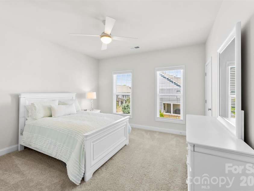 10141 Rainier Trail Drive, Huntersville, NC 28078.  MLS# CAR4375749, YatesRealty ID 25370. This is a well-appointed secondary bedroom, offering ample space and comfort. It features an upgraded, modern ceiling fan for enhanced air circulation and a comfortable ambiance, complemented by the convenienc