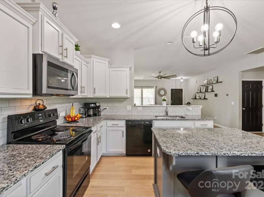 389 Whispering Hills Drive, Locust, NC 28097.  MLS# CAR4273635, YatesRealty ID 25374. White cabinets, granite, new light fixtures