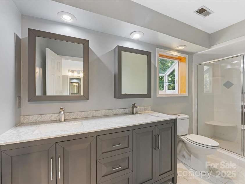 4601 Bournewood Lane, Charlotte, NC 28226.  MLS# CAR4278475, YatesRealty ID 25454. Gorgeous custom vanity with quartz counter.  Newer tile flooring too and mirrors with storage too!
