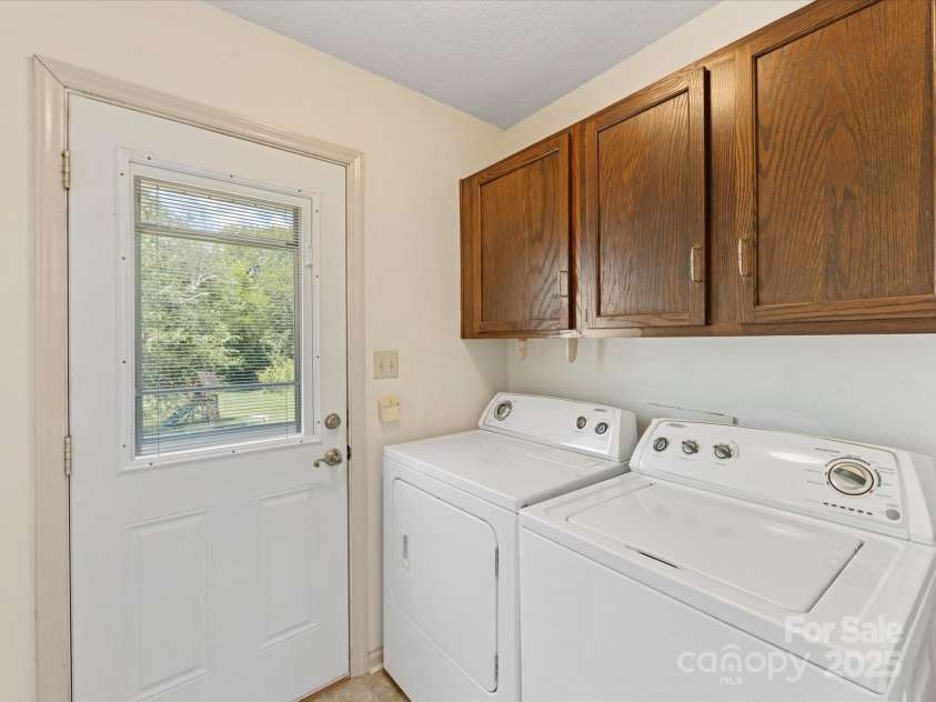 4601 Bournewood Lane, Charlotte, NC 28226.  MLS# CAR4278475, YatesRealty ID 25454. Laundry room with cabinetry has a door to the side porch entry from the driveway.